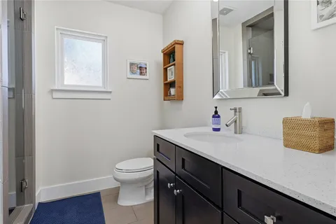 a bathroom with a granite countertop sink a toilet and mirror