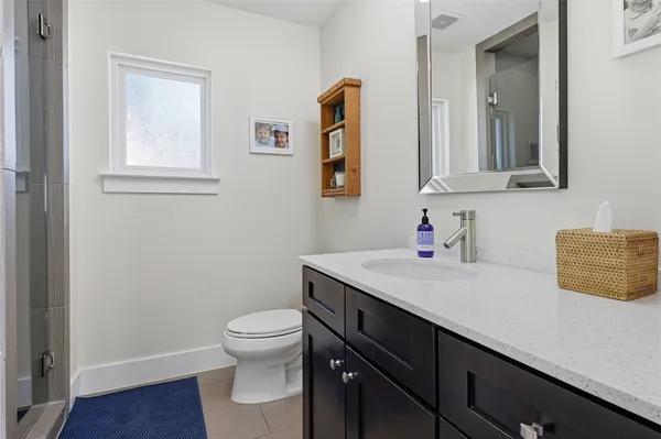 a bathroom with a granite countertop sink a toilet and mirror