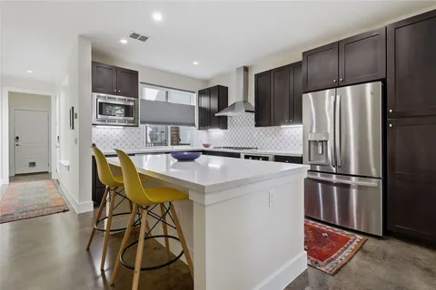 a kitchen with stainless steel appliances granite countertop a refrigerator a stove a sink and a refrigerator