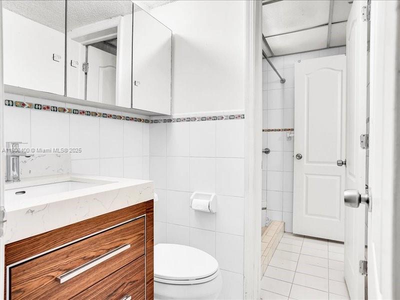 8990 Southwest 24th Street, Unit 33 Miami, FL 33165 - Photo 12 of 22 a bathroom with a sink a toilet and shower