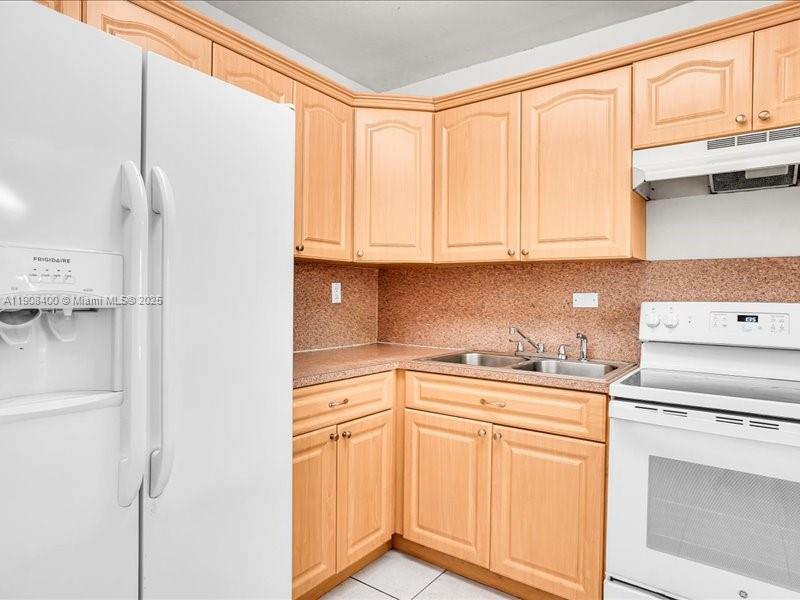 8990 Southwest 24th Street, Unit 33 Miami, FL 33165 - Photo 2 of 22 a kitchen with stainless steel appliances granite countertop a sink and cabinets with wooden floor