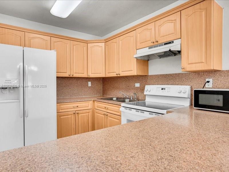 8990 Southwest 24th Street, Unit 33 Miami, FL 33165 - Photo 5 of 22 a kitchen with stainless steel appliances granite countertop a refrigerator sink and cabinets