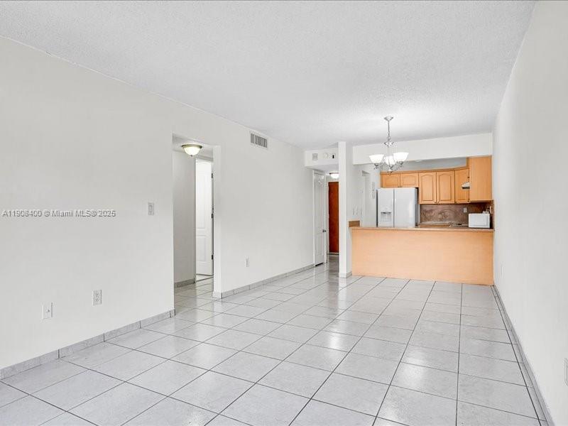 8990 Southwest 24th Street, Unit 33 Miami, FL 33165 - Photo 7 of 22 an empty room with kitchen view and natural light