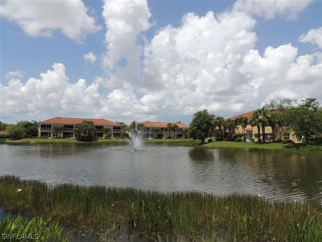 23891 Costa Del Sol Road, Unit 103 Bonita Springs, FL 34135 - Photo 11 of 12 a view of a lake with houses in the back