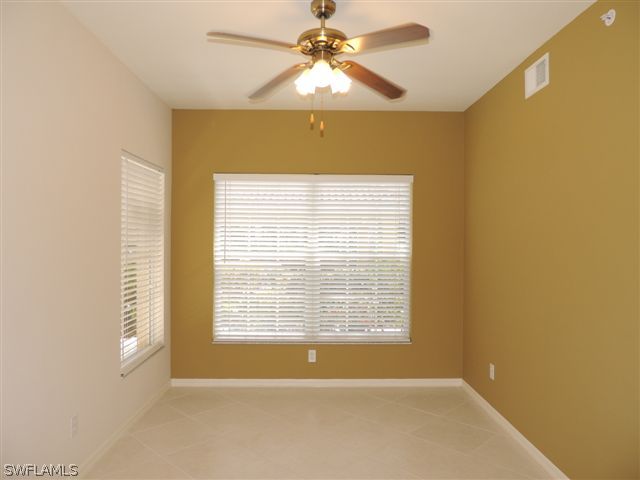 23891 Costa Del Sol Road, Unit 103 Bonita Springs, FL 34135 - Photo 4 of 12 a view of an empty room with chandelier fan and a window