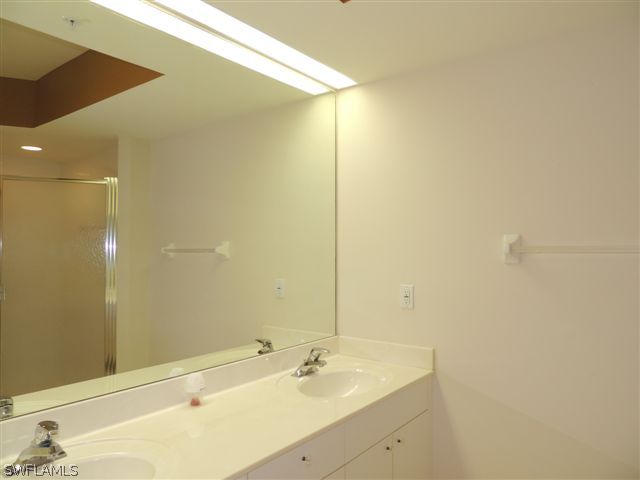 23891 Costa Del Sol Road, Unit 103 Bonita Springs, FL 34135 - Photo 7 of 12 a bathroom with a sink and a mirror