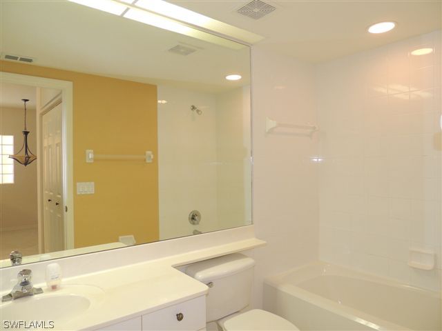 23891 Costa Del Sol Road, Unit 103 Bonita Springs, FL 34135 - Photo 9 of 12 a bathroom with a sink mirror toilet and bathtub