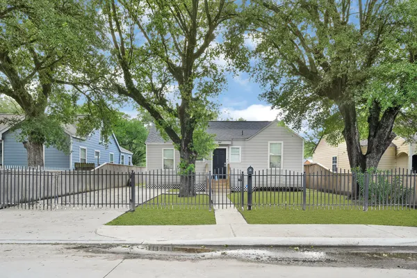 a view of a house with a fence and a tree