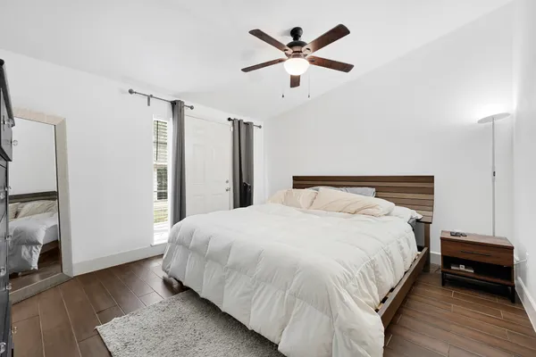a bedroom with a large bed and a chandelier