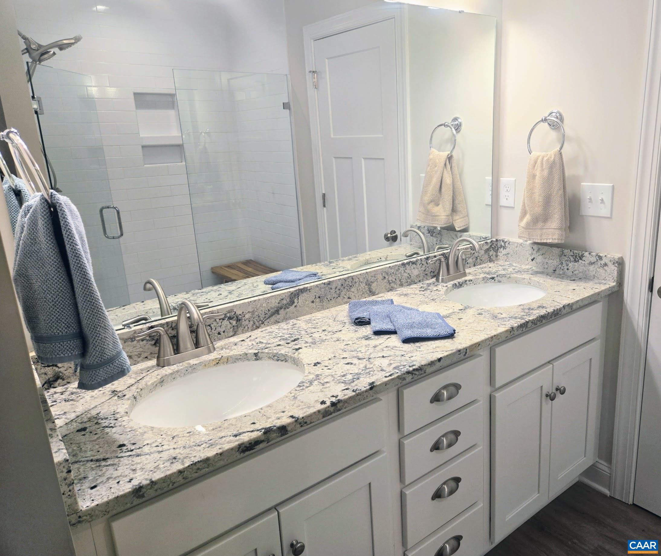 104 Blithe Court Charlottesville, VA 22901 - Photo 11 of 11 a bathroom with a granite countertop double sink and a mirror