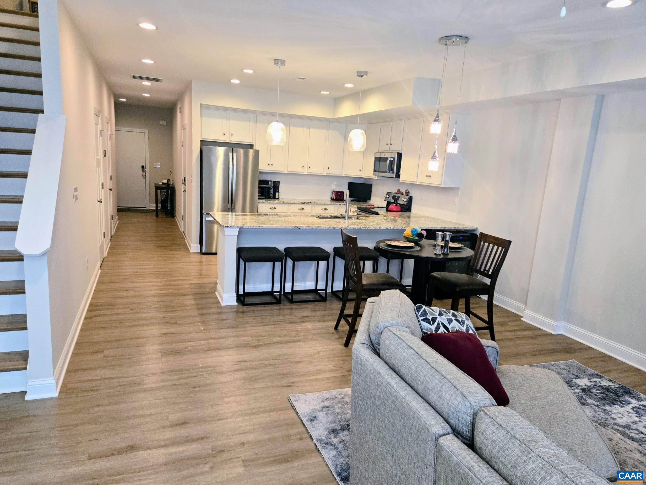 104 Blithe Court Charlottesville, VA 22901 - Photo 3 of 11 a living room with stainless steel appliances kitchen island granite countertop furniture wooden floor and a view of kitchen