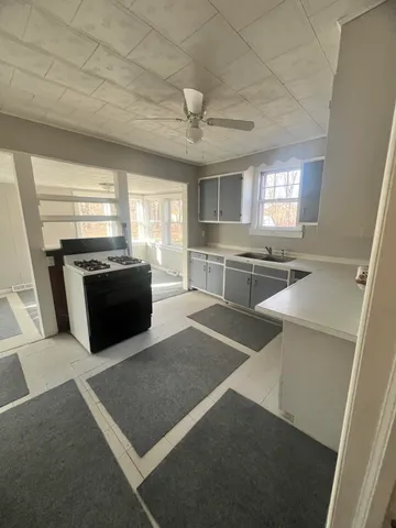 a large kitchen with granite countertop a stove sink and microwave