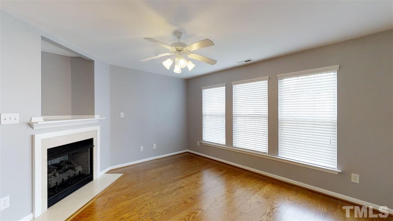 2133 Kedvale Avenue Raleigh, NC 27617 - Photo 10 of 25 a view of an empty room with chandelier fan and fire place