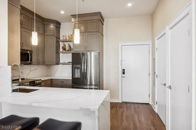 a kitchen that has a refrigerator a sink and a stove top oven