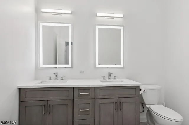 a bathroom with a sink vanity mirror and toilet