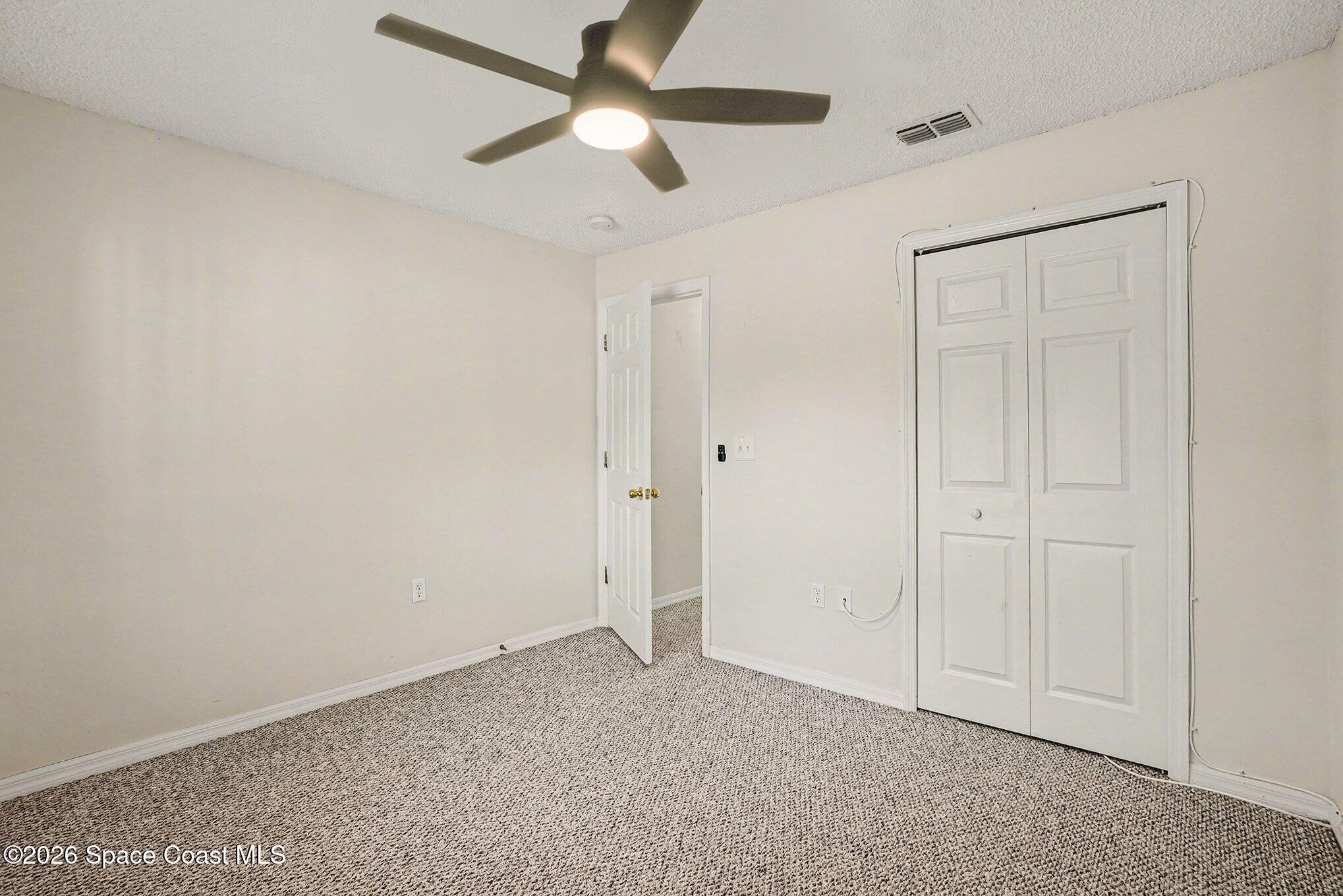 2268 Spring Creek Circle Palm Bay, FL 32905 - Photo 13 of 23 an empty room with closet and a ceiling fan