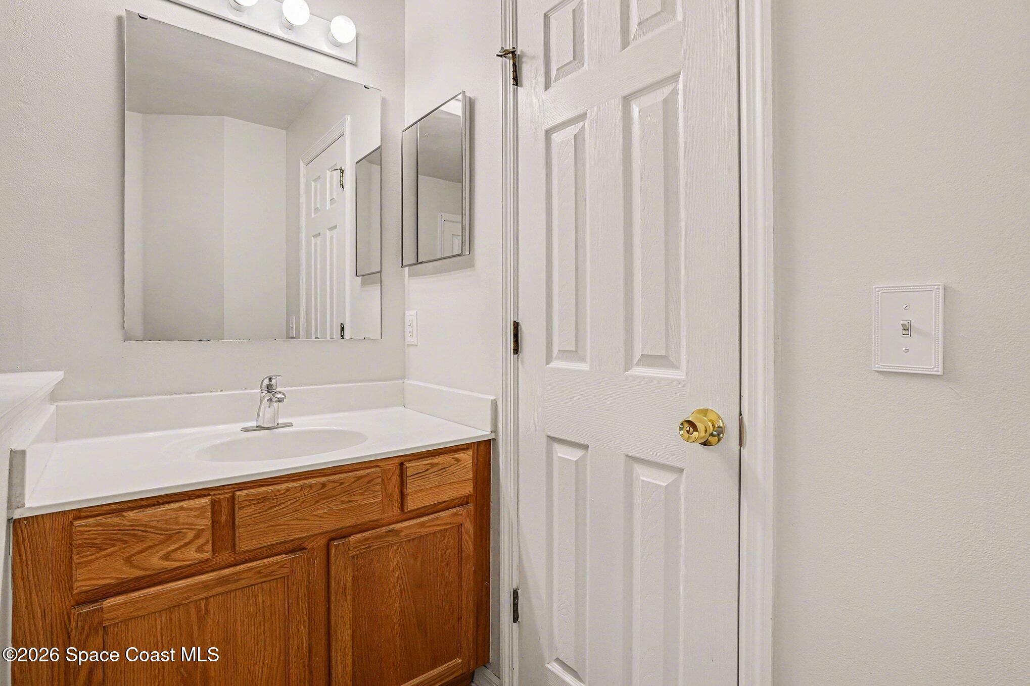 2268 Spring Creek Circle Palm Bay, FL 32905 - Photo 14 of 23 a bathroom with a sink and a mirror