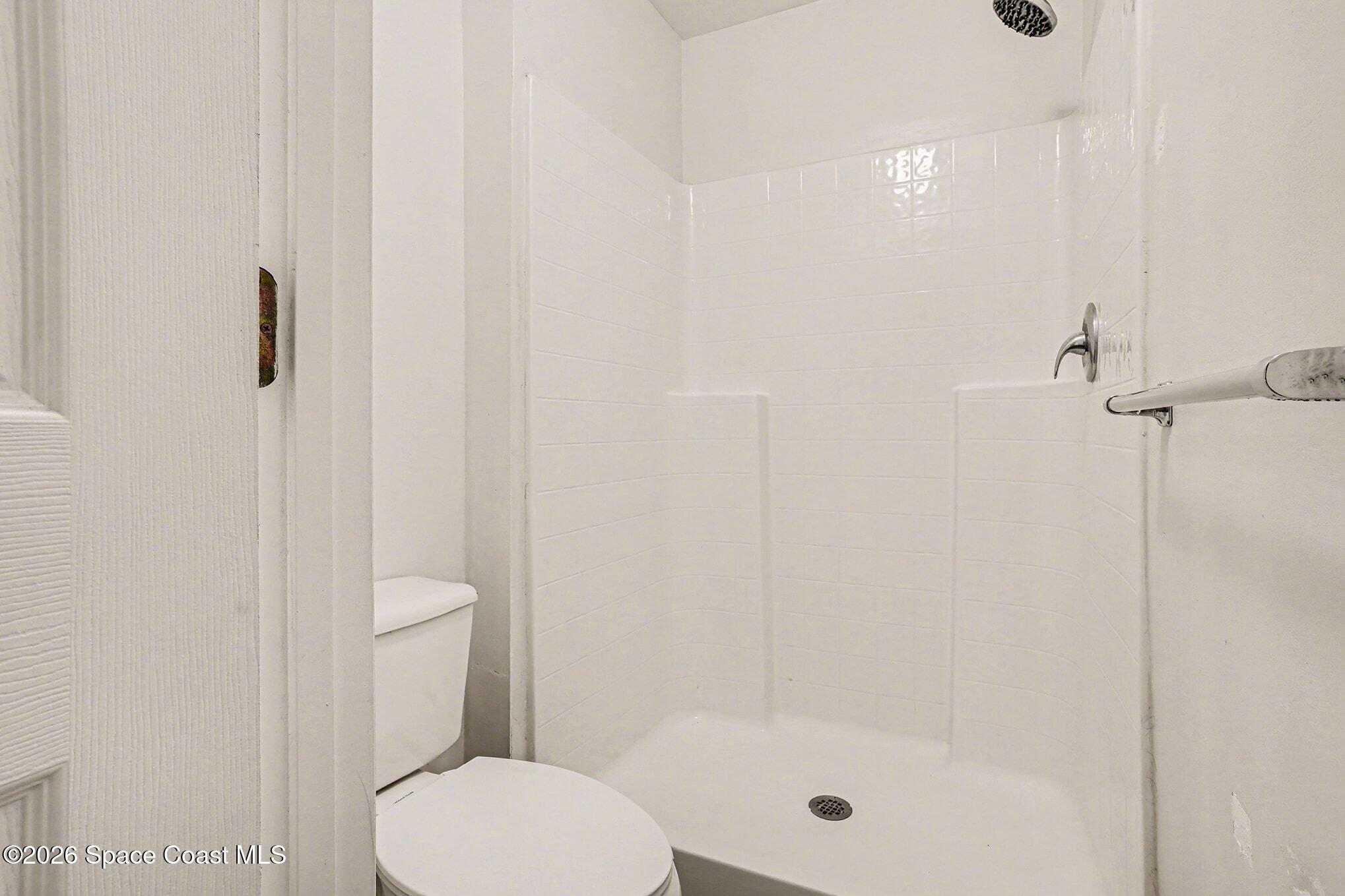 2268 Spring Creek Circle Palm Bay, FL 32905 - Photo 15 of 23 a white toilet sitting next to a shower