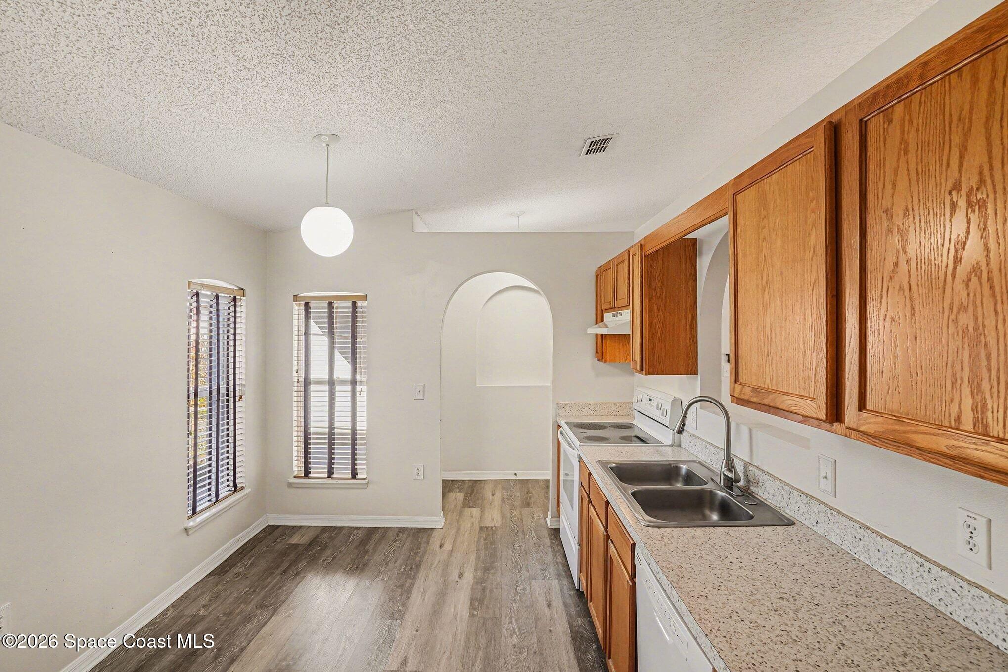 2268 Spring Creek Circle Palm Bay, FL 32905 - Photo 4 of 23 a kitchen with granite countertop a stove a sink and a window