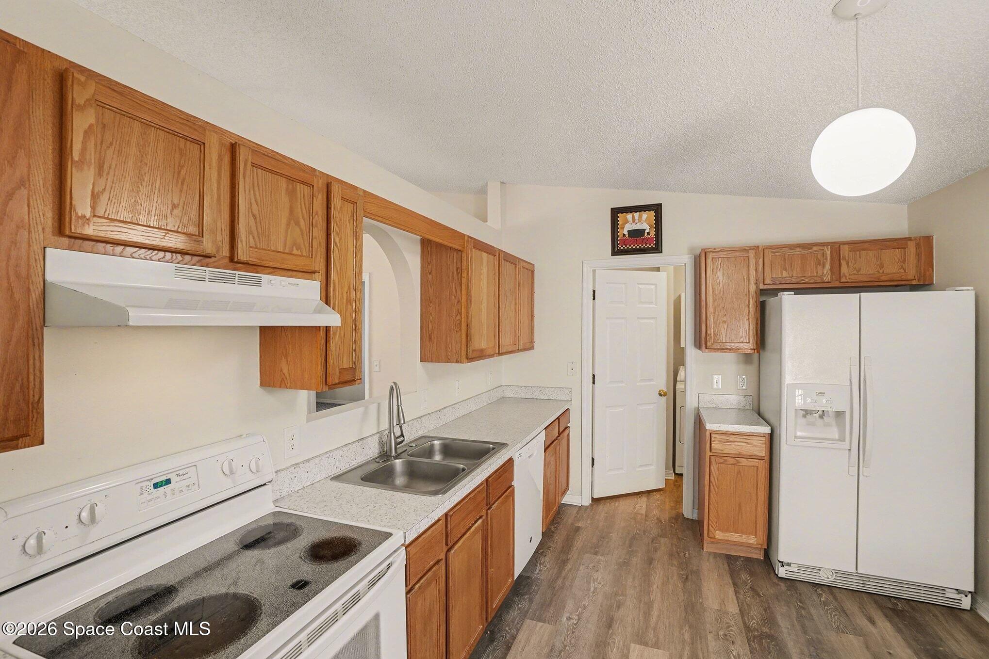 2268 Spring Creek Circle Palm Bay, FL 32905 - Photo 5 of 23 a kitchen with stainless steel appliances a stove a sink and a refrigerator