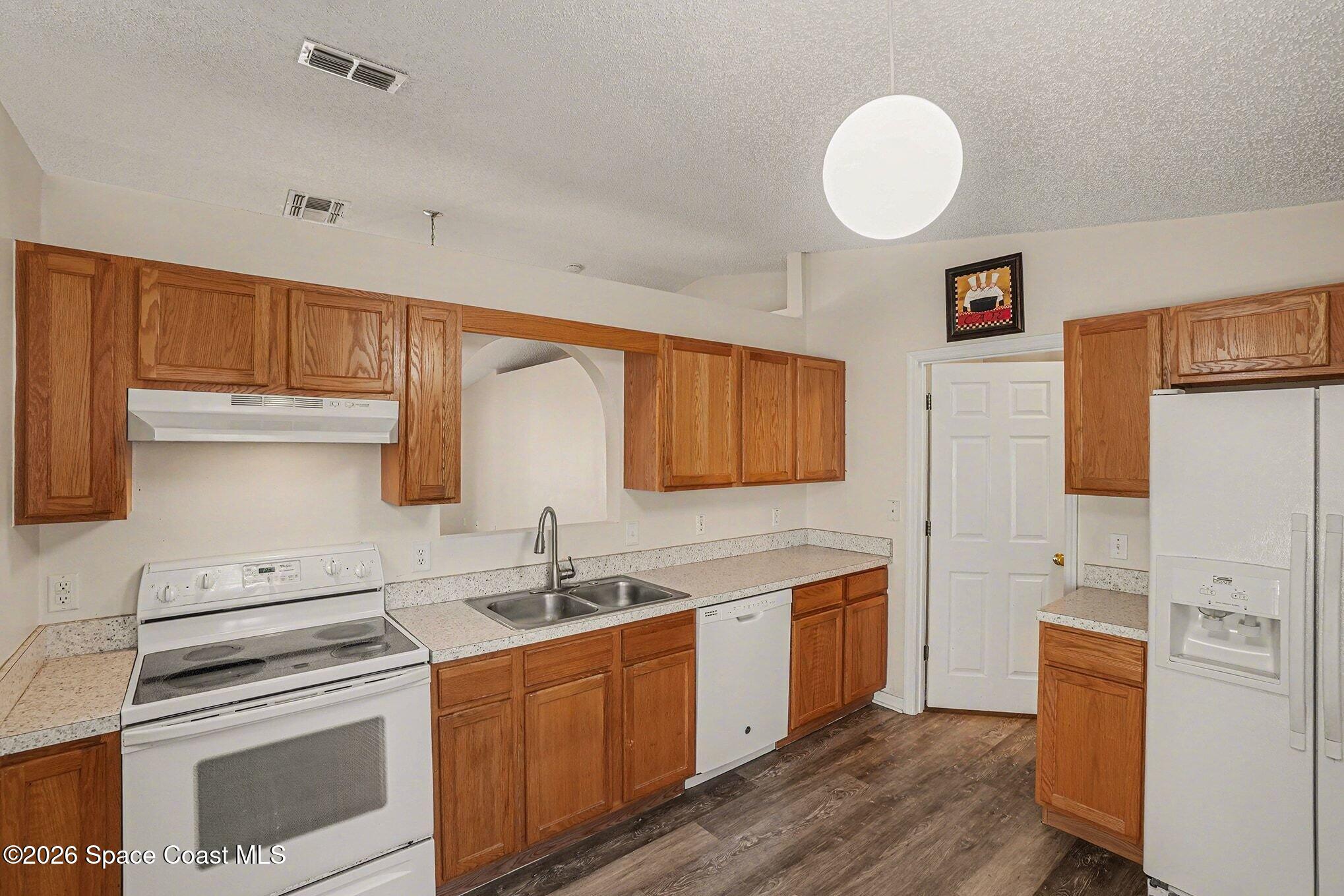 2268 Spring Creek Circle Palm Bay, FL 32905 - Photo 6 of 23 a kitchen with stainless steel appliances granite countertop a sink cabinets and wooden floor