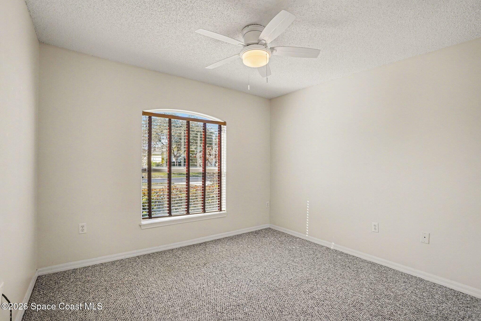 2268 Spring Creek Circle Palm Bay, FL 32905 - Photo 10 of 23 an empty room with windows and ceiling fan