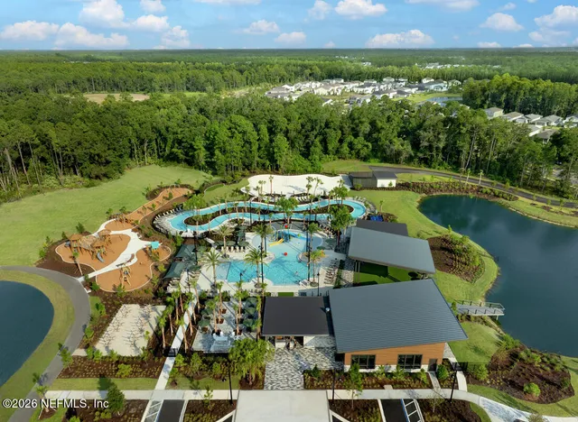 an aerial view of a house with swimming pool and outdoor seating