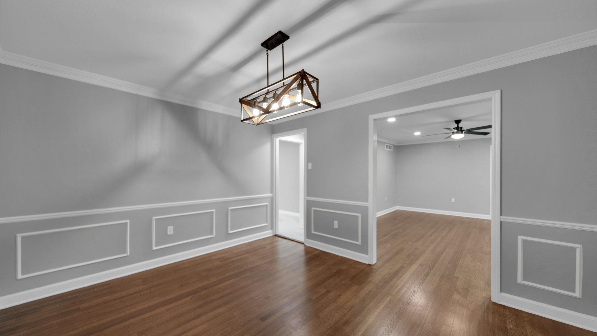 5256 Collingwood Road Memphis, TN 38117 - Photo 12 of 40 Unfurnished dining area with crown molding, dark wood-style floors, a decorative wall, a ceiling fan, and a chandelier