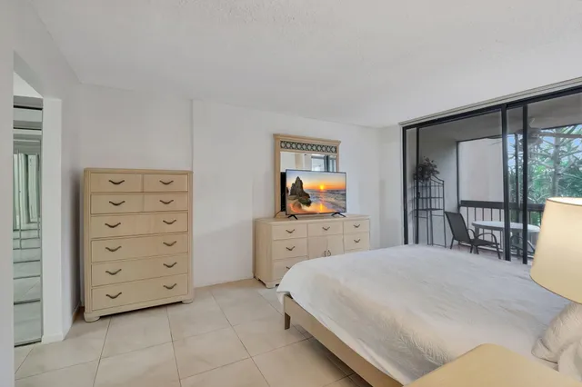 a bedroom with a bed a dresser and large mirror