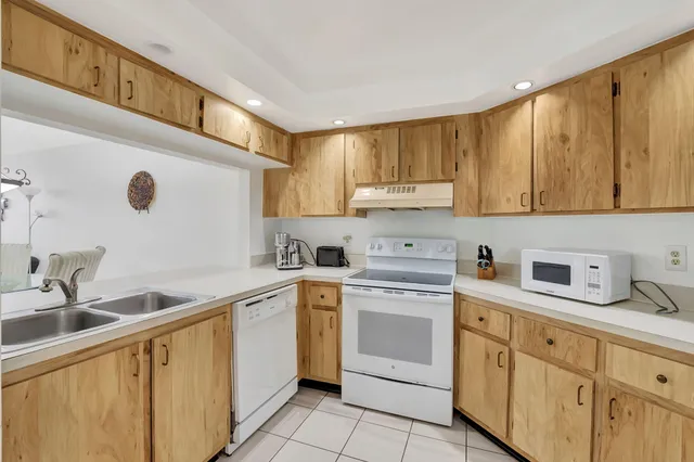 a kitchen with white cabinets sink and stove