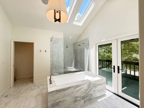 a spacious bedroom with a large bed and a chandelier