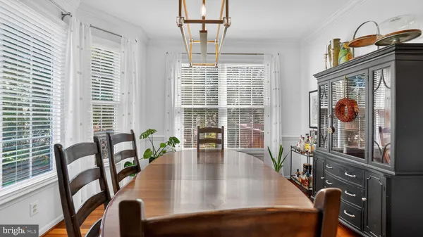 a kitchen with stainless steel appliances a stove a sink dishwasher a refrigerator with white cabinets and wooden floor