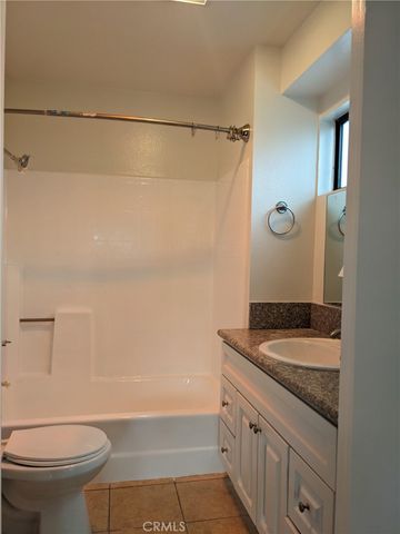 a bathroom with a granite countertop sink a toilet and shower