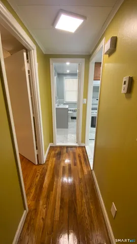 a view of an empty room with wooden floor