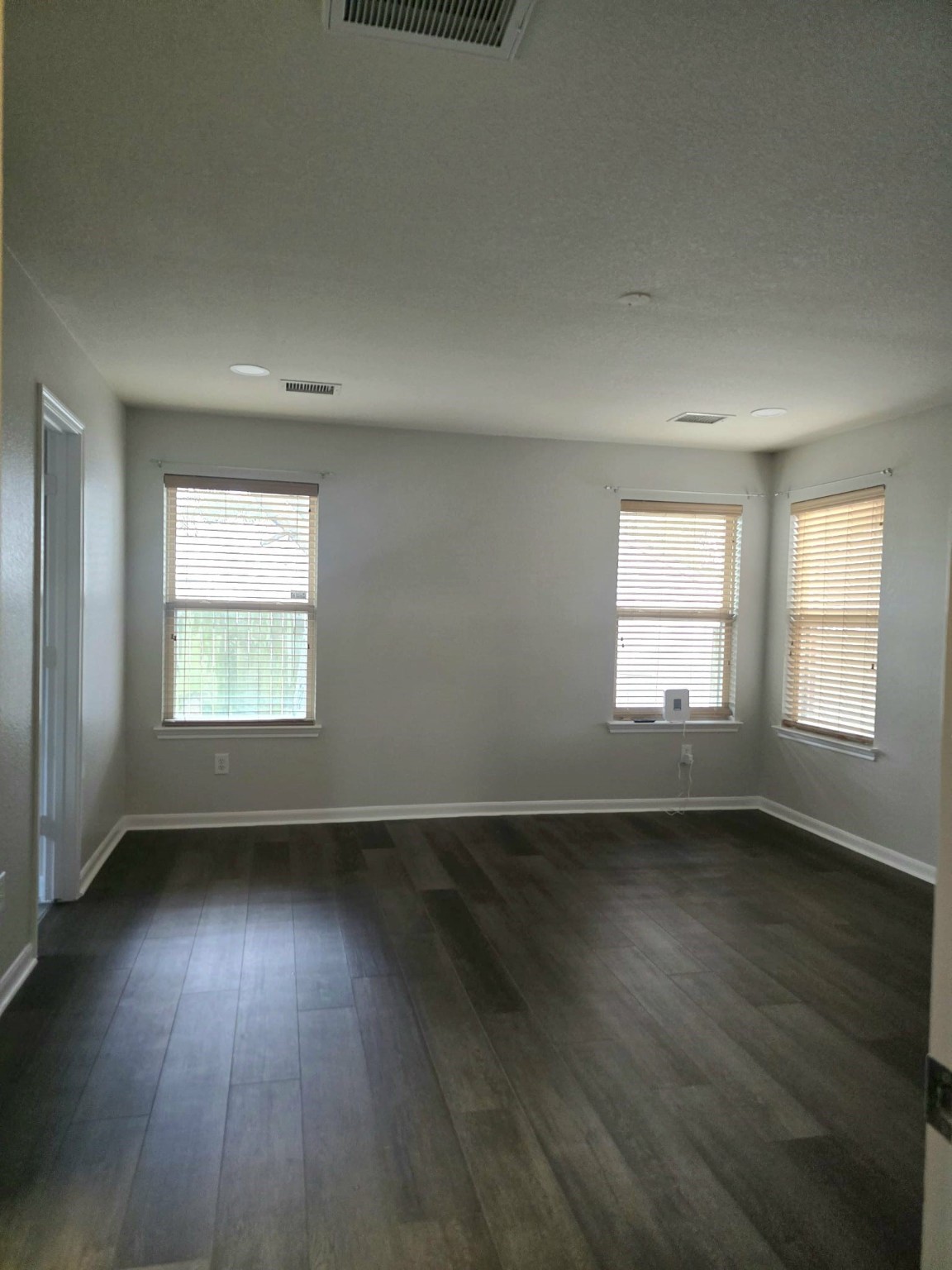 15618 Sweet Maple Court Houston, TX 77049 - Photo 11 of 23 an empty room with wooden floor and windows