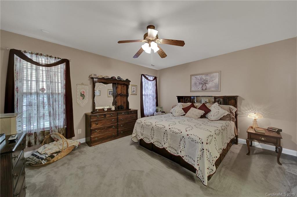 340 Garnet Court Fort Mill, SC 29708 - Photo 18 of 44 a bedroom with a bed and a chandelier
