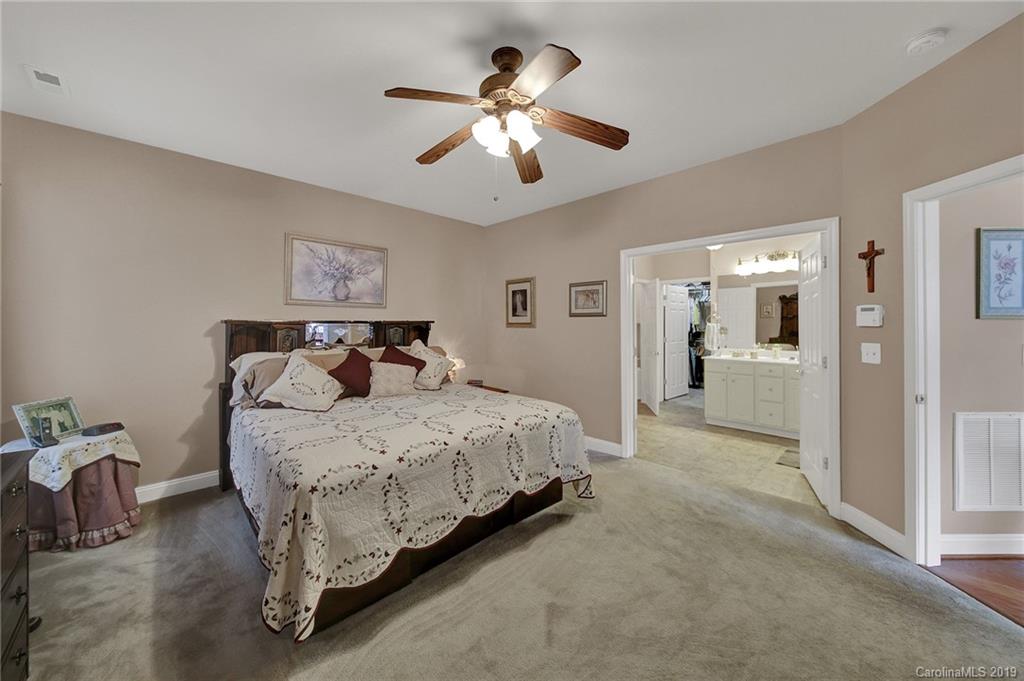 340 Garnet Court Fort Mill, SC 29708 - Photo 20 of 44 a spacious bedroom with a bed and a chandelier