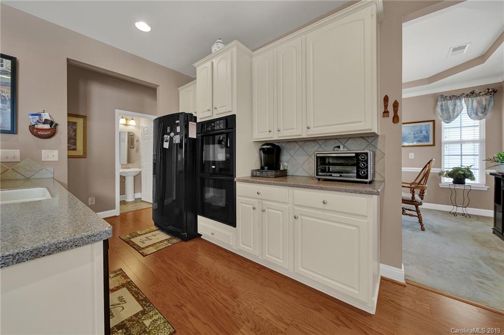 340 Garnet Court Fort Mill, SC 29708 - Photo 10 of 44 a kitchen with stainless steel appliances granite countertop a refrigerator a stove a sink and white cabinets with wooden floor