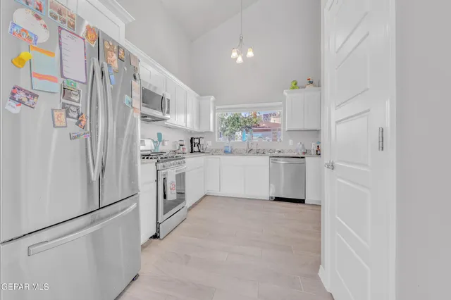a kitchen with stainless steel appliances a refrigerator sink and cabinets