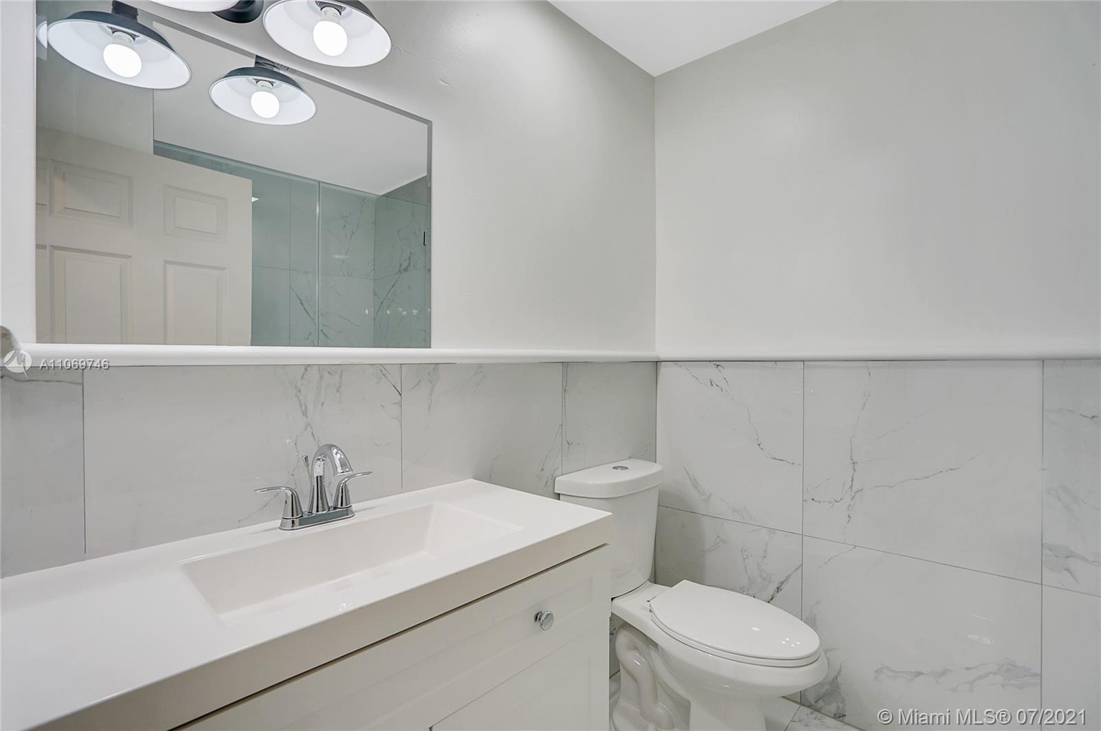 12121 Southwest 271st Street Homestead, FL 33032 - Photo 2 of 20 a bathroom with a sink a toilet and vanity