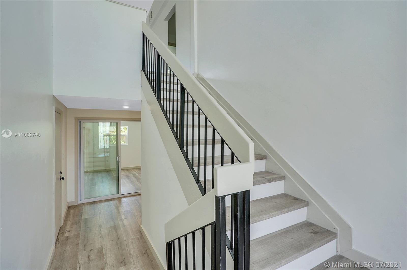 12121 Southwest 271st Street Homestead, FL 33032 - Photo 12 of 20 a view of staircase with wooden floor and white walls
