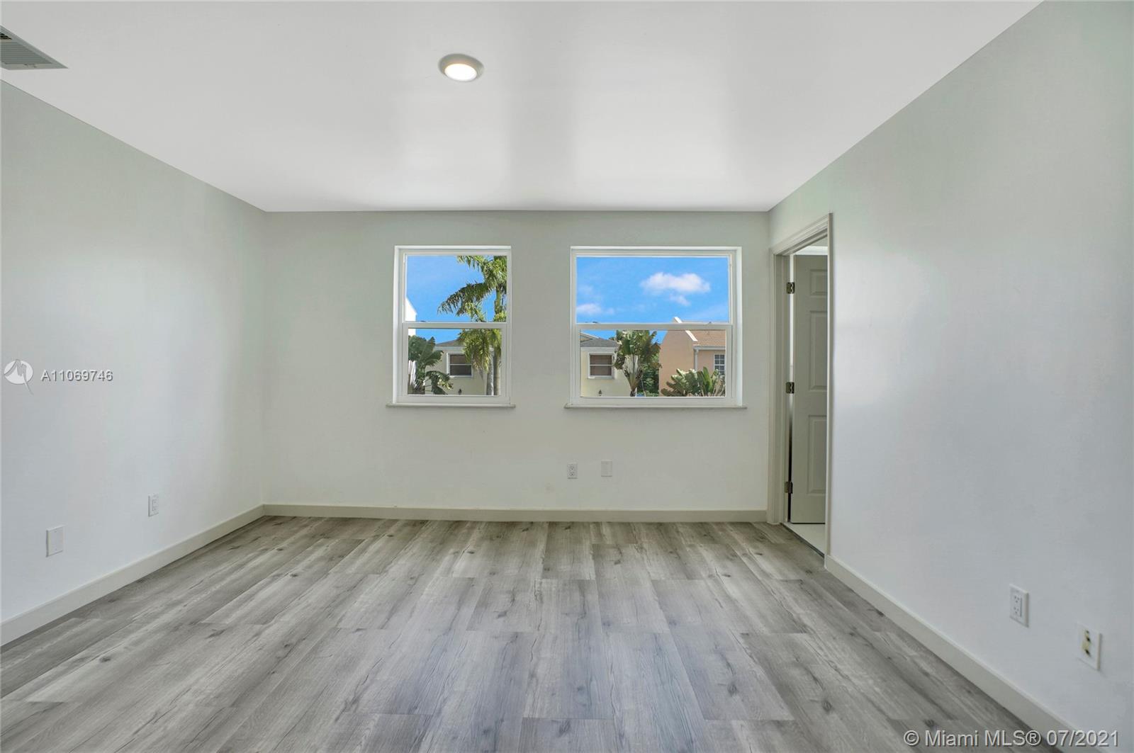 12121 Southwest 271st Street Homestead, FL 33032 - Photo 15 of 20 an empty room with wooden floor and windows