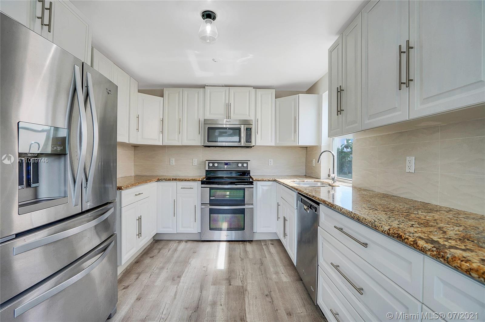 12121 Southwest 271st Street Homestead, FL 33032 - Photo 6 of 20 a kitchen with granite countertop white cabinets and stainless steel appliances
