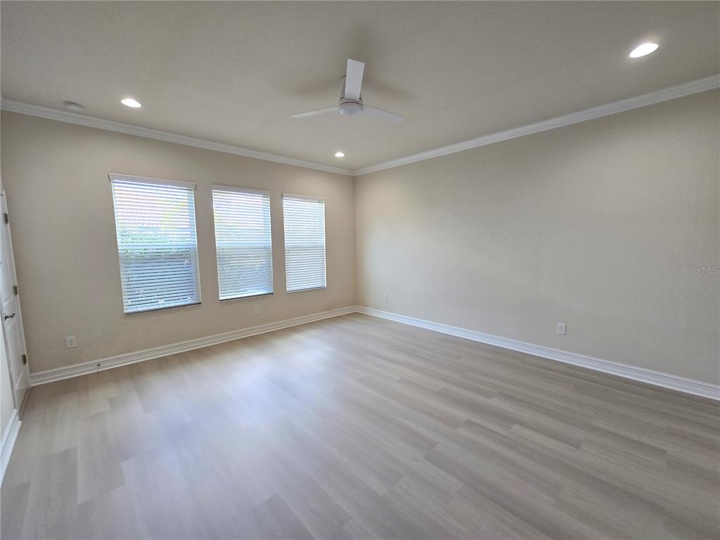 11925 Perennial Place Lakewood Ranch, FL 34211 - Photo 11 of 39 an empty room with wooden floor and windows