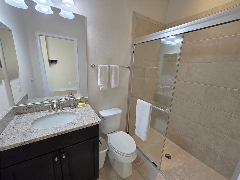 11925 Perennial Place Lakewood Ranch, FL 34211 - Photo 17 of 39 a bathroom with a granite countertop sink toilet and shower
