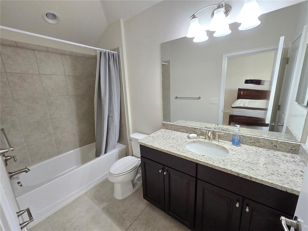 11925 Perennial Place Lakewood Ranch, FL 34211 - Photo 20 of 39 a spacious bathroom with a granite countertop sink a toilet a mirror a bathtub and shower