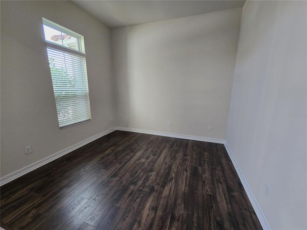 11925 Perennial Place Lakewood Ranch, FL 34211 - Photo 23 of 39 an empty room with wooden floor and windows