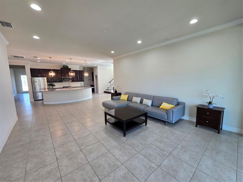 11925 Perennial Place Lakewood Ranch, FL 34211 - Photo 3 of 39 a living room with furniture and kitchen view