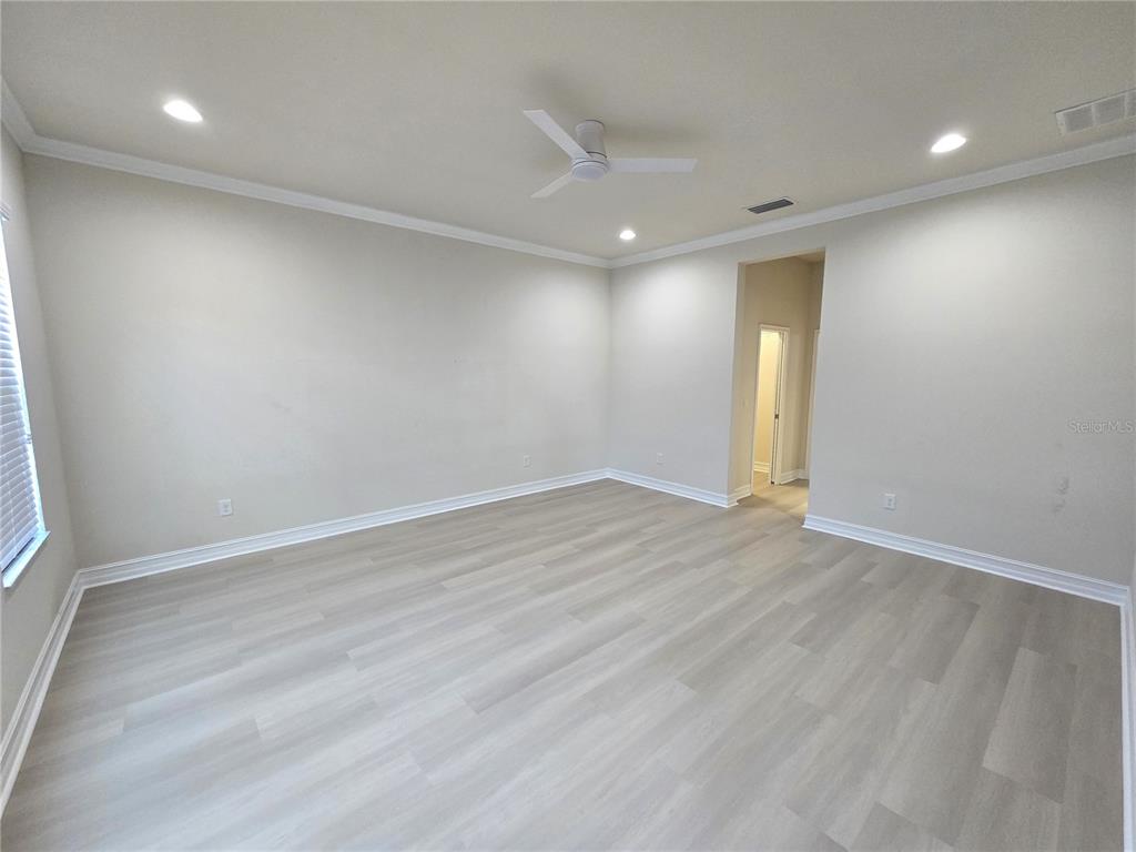 11925 Perennial Place Lakewood Ranch, FL 34211 - Photo 10 of 39 an empty room with wooden floor and windows