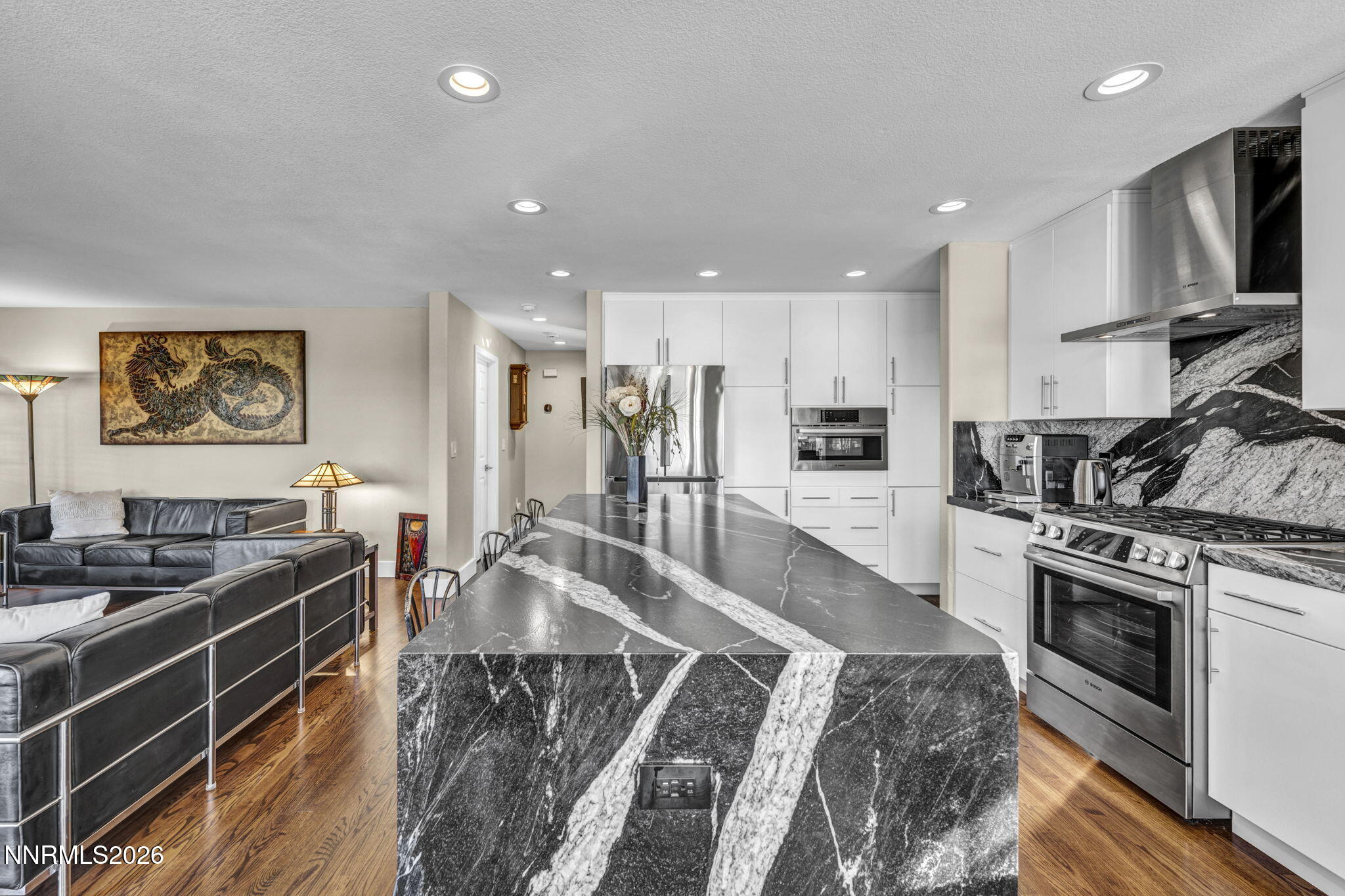 2296 Oak Ridge Drive Carson City, NV 89703 - Photo 19 of 71 a large kitchen with stainless steel appliances granite countertop a stove top oven a sink dishwasher a dining table and chairs with wooden floor